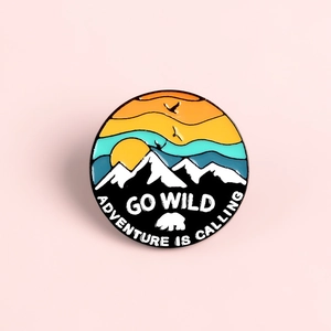 Go Wild enamel pin with mountain sunset and polar bear design for outdoor adventure