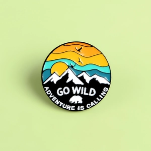 Detail of enameled badge with snow mountains, polar bear and Adventure Is Calling text
