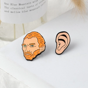 Artistic Van Gogh portrait and ear enamel pin set for jackets on a minimalist display