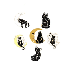 Enamel cat brooches set with black and white cats and moon phases in gold plating