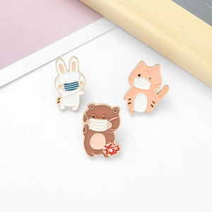 Three enamel animal pins featuring a bunny, cat, and bear wearing protective face masks