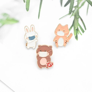 Detailed close-up of cartoon animal enamel pins featuring a rabbit, cat, and bear with masks