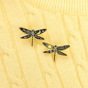Detailed pair of enamel dragonfly pins featuring celestial moon and sun motifs