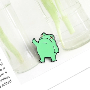 Vue détaillée d'un pin's en émail grenouille verte rigolote avec un geste sarcastique