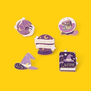 Detail view of 5-piece purple witch enamel pins set with magic books and crystal ball