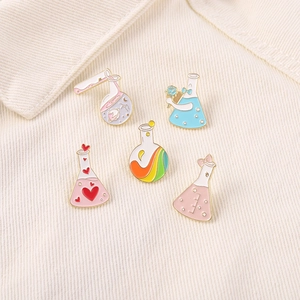 Set of 5 cartoon enamel pins featuring pink heart science flasks on fabric background