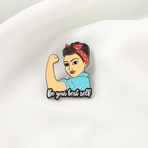 Détail de la broche émaillée Be Your Best Self avec motif Rosie sur tissu blanc plissé