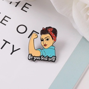 Gros plan d'une broche en émail avec motif Rosie the Riveter et message de motivation