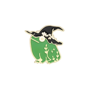 Détail d'une broche grenouille émaillée avec chapeau de sorcière et motifs dorés