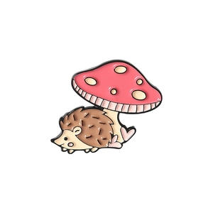 Détail d'un pin's émaillé avec un hérisson sous un champignon rose à pois de style dessin animé