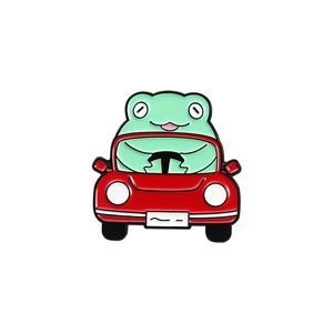 Vue détaillée du pin's émaillé grenouille verte conduisant une voiture rouge en alliage