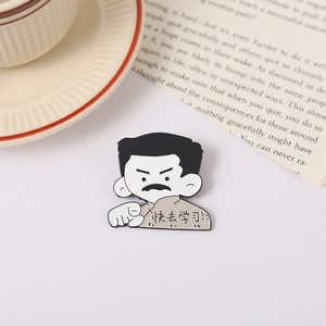 Detail of cartoon literary metal badge with Chinese text shown on an open book
