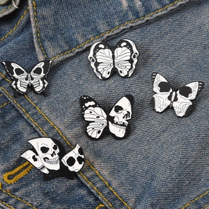 Détail de broches en émail style gothique avec papillons et crânes sur une veste en jean