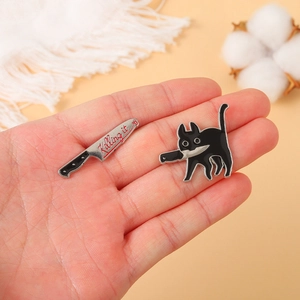 Macro detail of cartoon cat pin holding a knife and a killing it text dagger badge