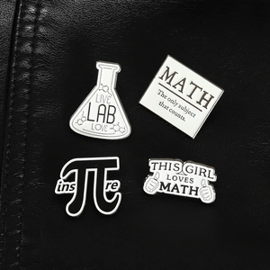 Gros plan d'épingles en émail avec symbole pi et flacons de chimie sur cuir noir texturé