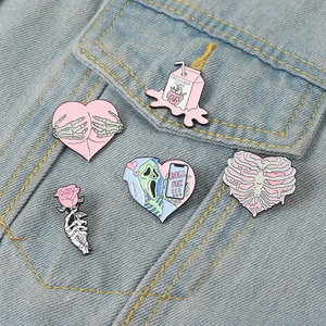 Lot de cinq épingles en émail rose créatives présentées sur une poche en jean
