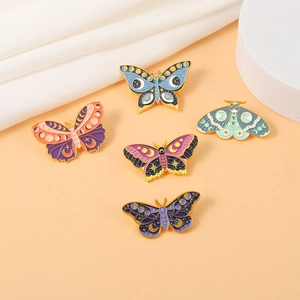 Detailed view of five vintage enamel butterfly brooches with celestial moon and star motifs