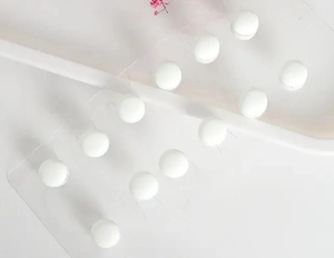 Gros plan de perles magnétiques blanches pour écharpes sur présentoir acrylique