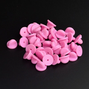 Dettaglio delle chiusure per spille in gomma rosa su uno sfondo nero opaco
