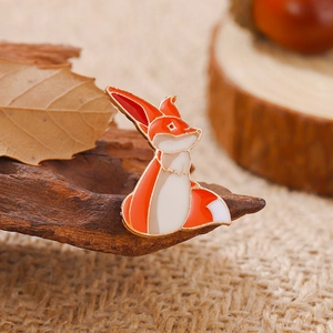 Broche renard mignon en émail et plaqué or sur un fond rustique d'automne chaleureux