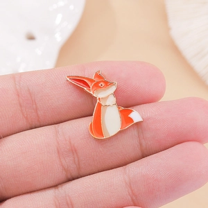 Gros plan du pin's en émail renard orange mignon avec bords en alliage doré