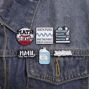 Detailed set of 6 math-themed creative enamel pins displayed on denim fabric background