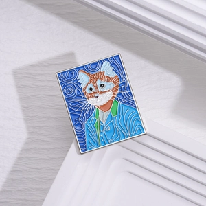 Detailed view of Van Gogh style orange cat enamel pin on a white geometric stand