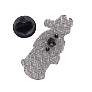 Detail view of metal pin back with textured geometric pattern and black rubber clutches