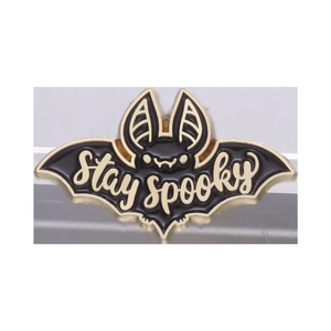 Détail de la broche chauve-souris en émail noir et or avec inscription Stay Spooky