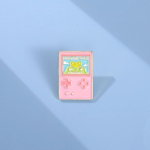 Macro view of pink enamel frog game console brooch with high-gloss metallic finish