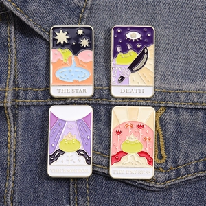 Set of four colorful tarot frog enamel pins displayed on a blue denim jacket pocket