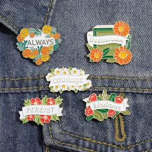Lot de pin's en émail colorés avec fleurs et citations sur une veste en jean
