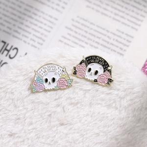 Detailed macro of enamel skull and flower pins with Til Death We Do Art text