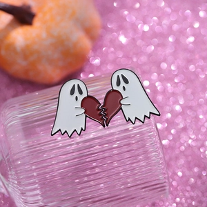 Detailed macro view of cartoon ghost enamel pins with broken heart pieces for Halloween