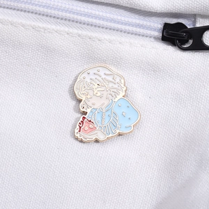 Detailed view of Howl and Calcifer enamel pin on white canvas bag with gold metal lines