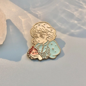 Detailed macro view of an enamel pin featuring a girl holding fire with gold plating