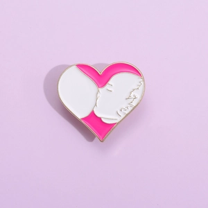 Detail of pink heart-shaped enamel pin featuring a mother breastfeeding a baby