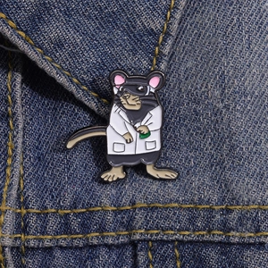 Détail d'un pin's en émail en forme de souris médecin sur fond de denim bleu