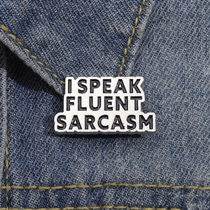Enamel pin with I SPEAK FLUENT SARCASM text on blue denim collar for creative style