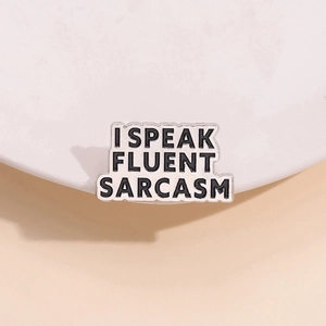 Minimalist enamel pin featuring I Speak Fluent Sarcasm text on pink background
