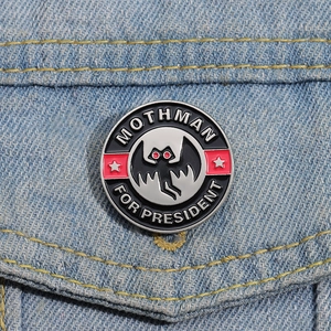 Gros plan d'un badge émaillé Mothman For President sur une poche de veste en jean