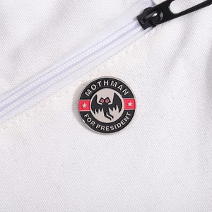 Détail de l'épingle en émail Mothman For President sur un sac en toile blanche
