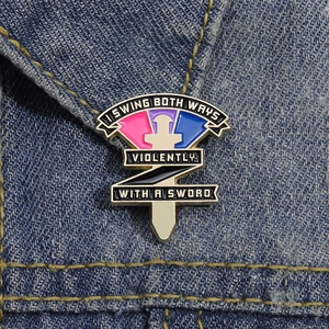 Emaille-Dolch-Anstecknadel mit buntem Hintergrund auf einem dunkelblauen Denim-Jackenkragen