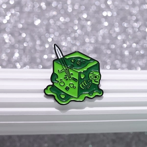 Fantasy Gelatinous Cube enamel pin with skull, sword, and dice in green resin