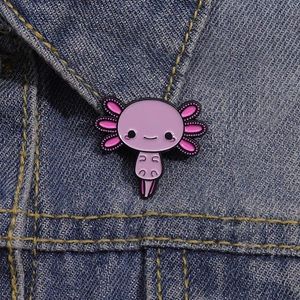 Detail view of a cute purple axolotl enamel pin styled on a blue denim jacket lapel