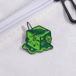 Fantasy green slime enamel pin featuring skull and sword on white canvas backpack