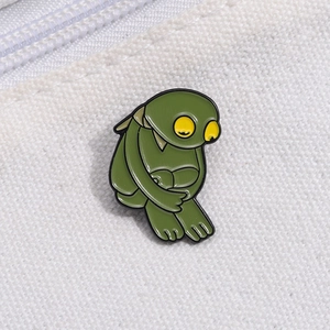 Broche grenouille de dessin animé vert avec grands yeux jaunes sur toile blanche