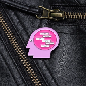 Detail of pink brain head enamel pin with text Don't grow up it's a trap on leather jacket