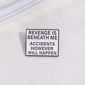 Close-up of square enamel badge with humorous quote on white canvas fabric