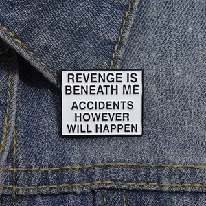 Macro shot of a rectangular enamel badge with humor quote on dark blue denim fabric